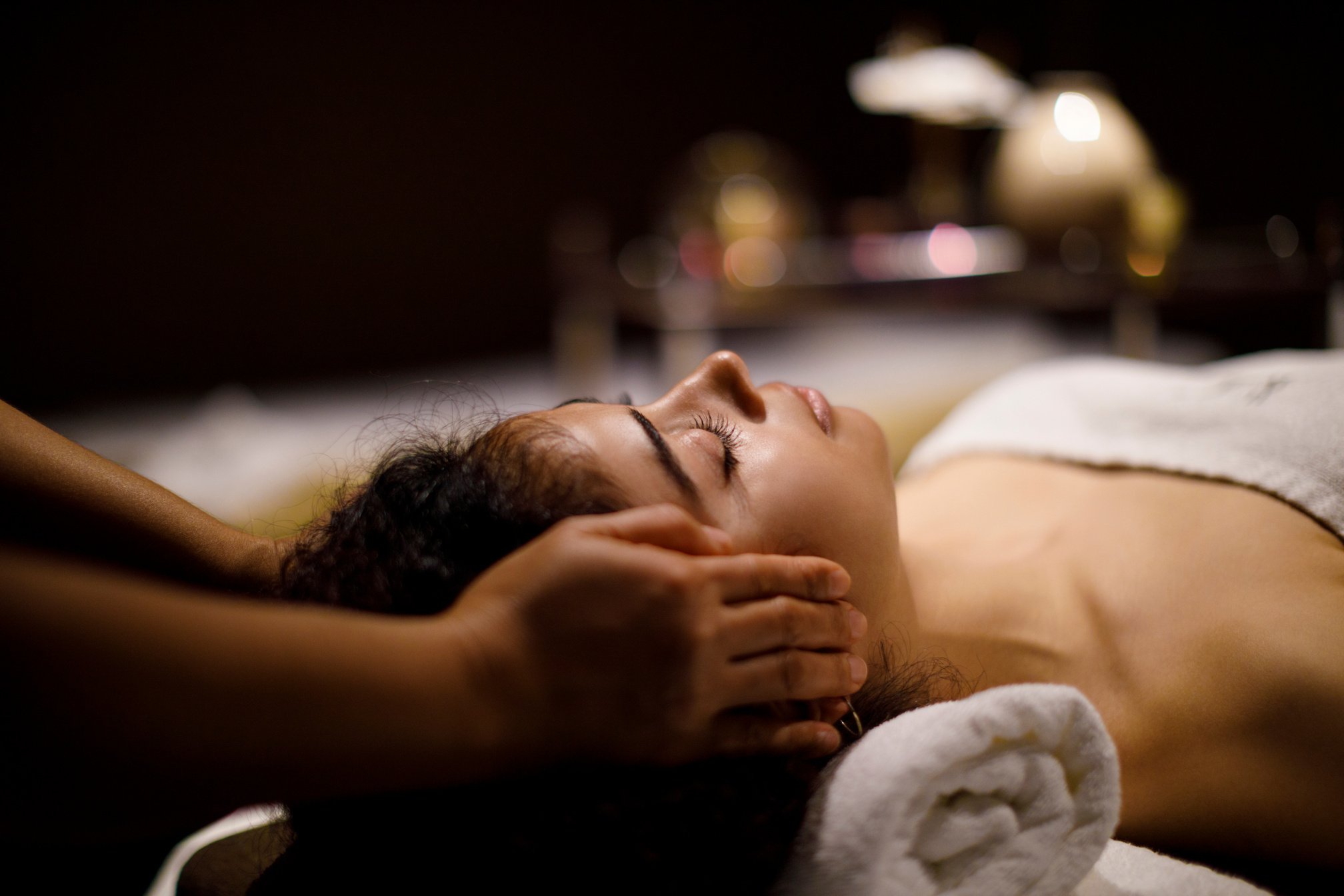 Woman enjoying head massage in spa center